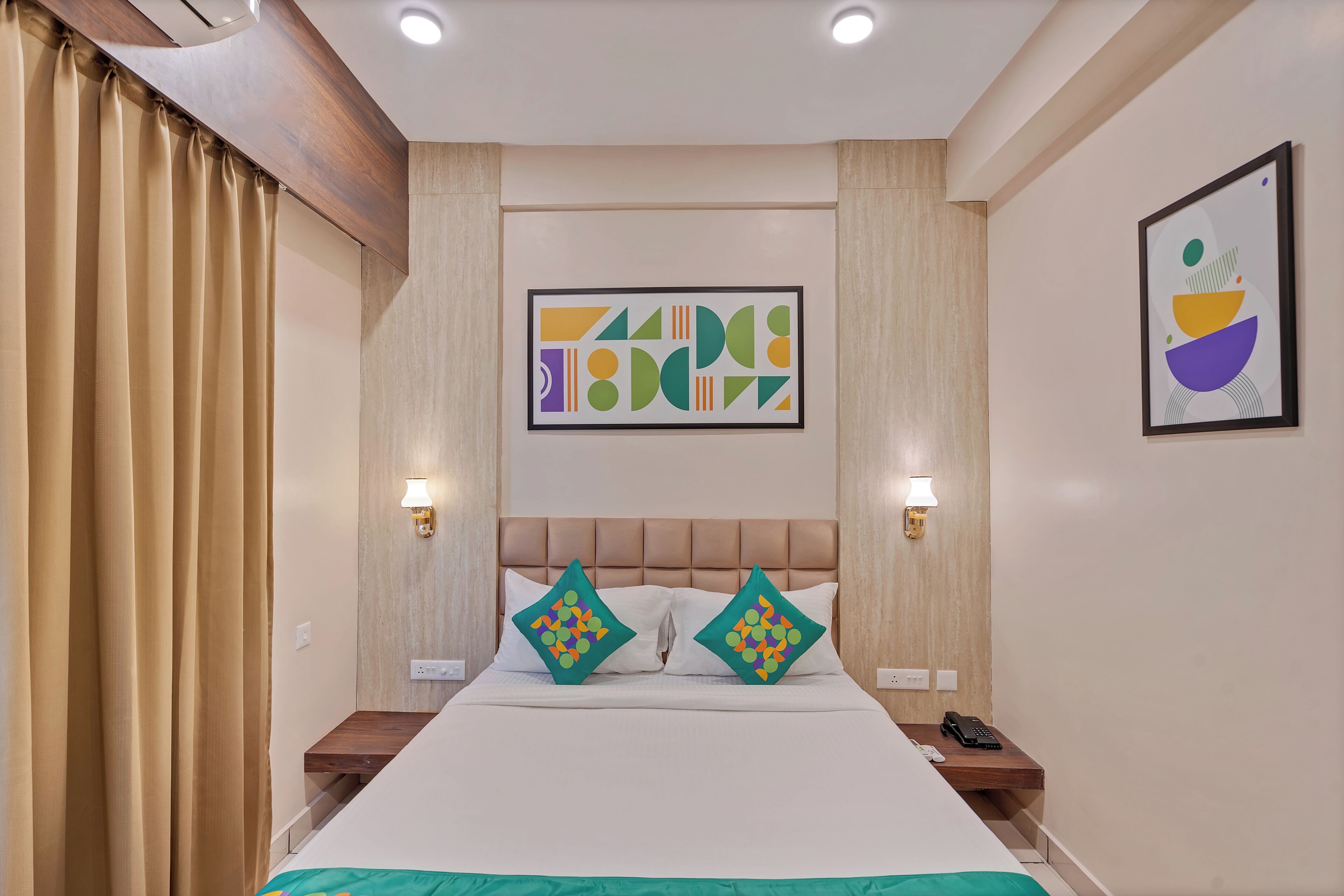 A hotel room with a large bed, two bedside tables, a headboard, and two wall-mounted lamps.