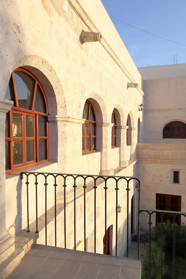 A building with arched windows and a balcony with a metal railing.