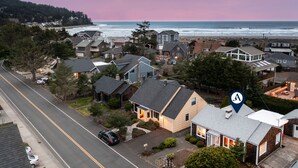 A coastal residential area with houses, a road, and a view of the ocean. - Cove Beach Retreat • Fire Pit + Golf Course Nearby | Grey Oak (Seaside)