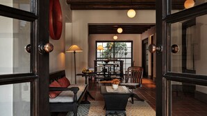 A cozy interior with a sofa, a small table with a vase, and a bookshelf. - Dali Ancient Town Anyu Hotel (Dali)