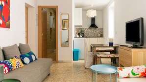 A living room with a sofa, a television, and a dining table. - Holiday Home in Cadiz by the Sea (Cadiz)