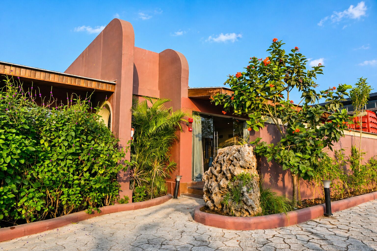 A building with a unique architectural design, featuring a prominent arch and a red facade.