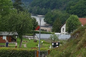 A rural setting with a small building, a pathway, and a hill in the background. - Top Ferienwohnung am Diemelsee (Diemelsee)