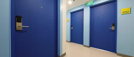 A corridor with blue doors, an EXIT sign, and a room number 1212.