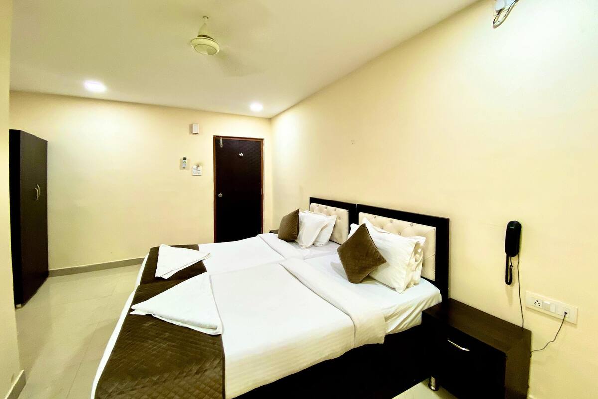 Una habitación de hotel con una cama, mesita de noche y teléfono.