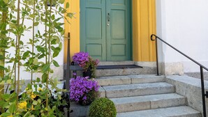 A set of stone steps leading to a green door with a yellow archway. - The White brig (Hudiksvall)