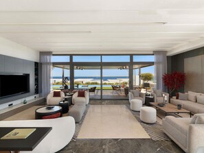 A modern living room with a large TV, comfortable seating, and a view of the beach. - Club Prive By Rixos Sharm El Sheikh (Sharm El Sheikh)