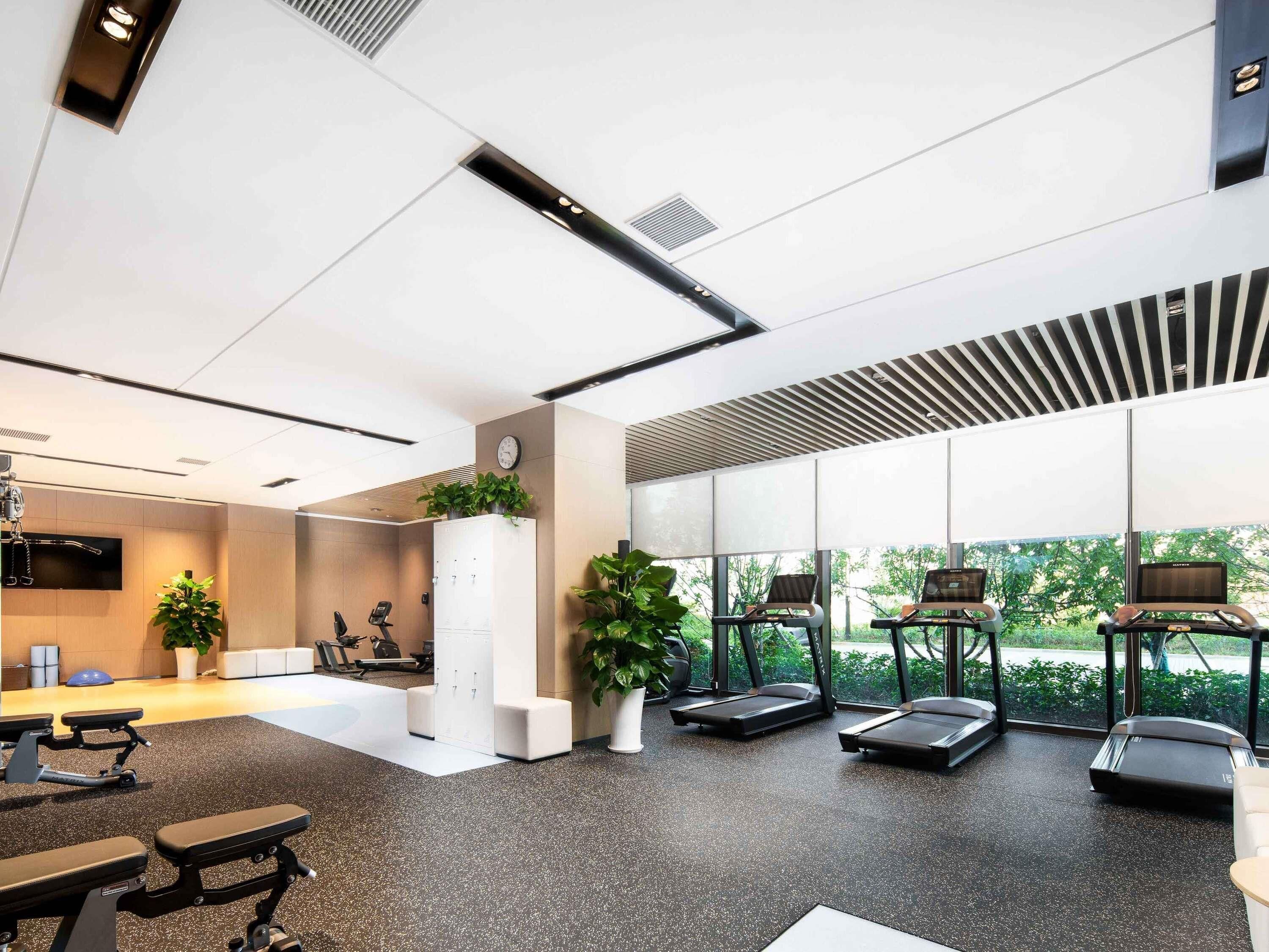 A modern gym with treadmills, stationary bikes, and weight machines.