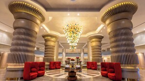 A lobby with a central chandelier, red seating, and unique architectural columns. - Rixos Radamis Sharm El Sheikh (Sharm El Sheikh)