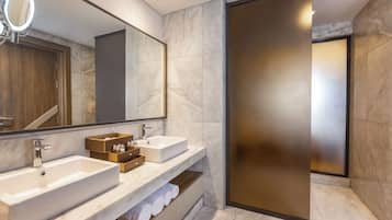Ein modernes Badezimmer mit zwei Waschbecken, einem großen Spiegel und einem Handtuchhalter.
