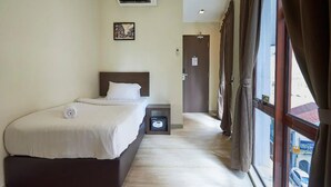 A hotel room with a bed, an air conditioner, a nightstand, a door, and a window with curtains. - Hotel O Senja Hostel Chinatown (Kuala Lumpur)