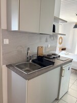 Frigobar, placa de cocina, tetera/pava eléctrica, utensilios de cocina