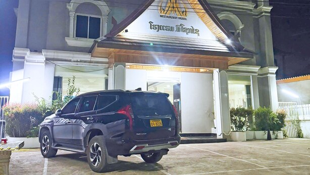 Un edificio con un letrero grande que dice "Meesoway Hotel" y una camioneta SUV estacionada frente.
