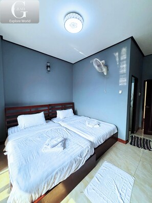 A bedroom with a large bed, a ceiling fan, and a light fixture. - Vang Vieng Misokxay Hotel (Vang Vieng)
