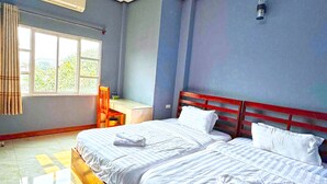 Habitación de hotel con dos camas, un escritorio y una ventana.