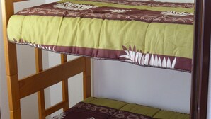 A bunk bed with a green and brown patterned bedspread. - Location Narbonne Plage (Villefranche-de-Rouergue (12))