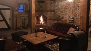 Una habitación acogedora con chimenea de piedra, muebles de cuero y una mesa de madera.