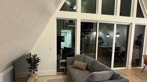 Een moderne woonkamer met een grijze modulaire bank, een flatscreen televisie en een houten salontafel.