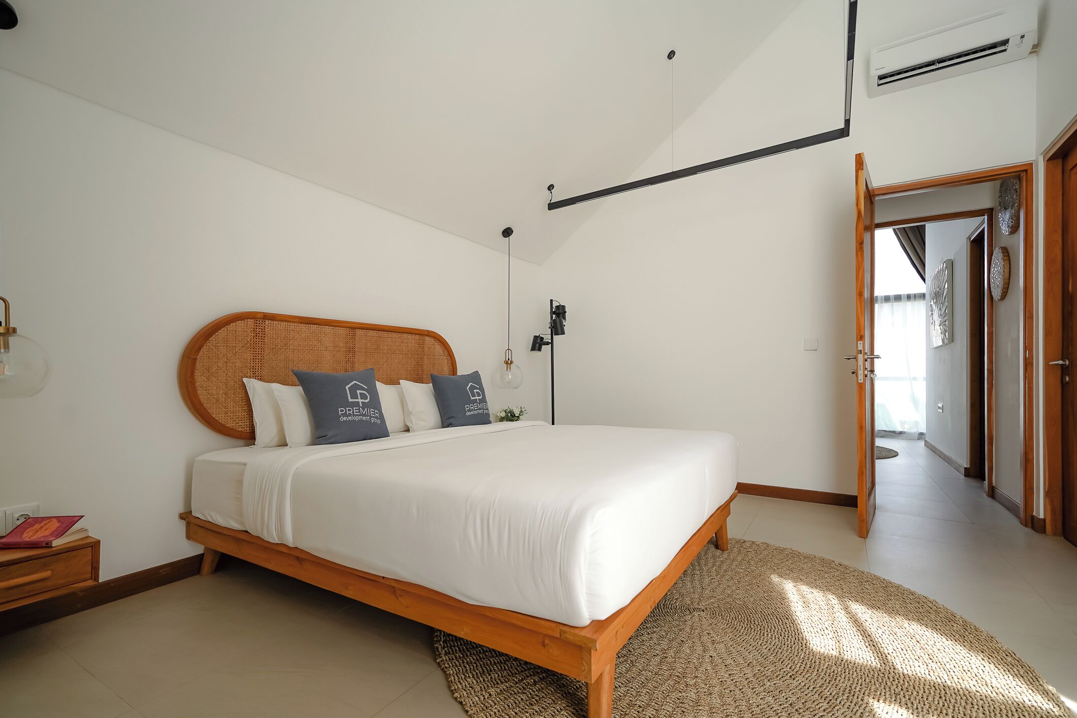 Un dormitorio con una cama de madera, ropa de cama blanca y una alfombra tejida.