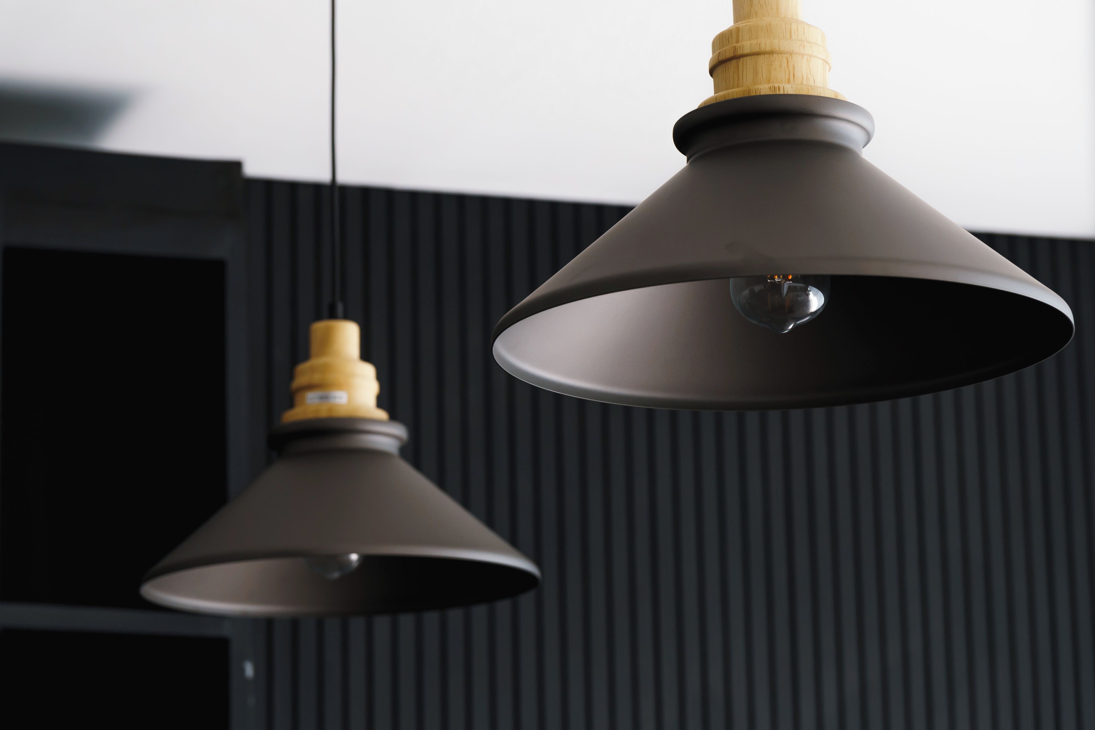 Twee hanglampen met houten kap aan het plafond.