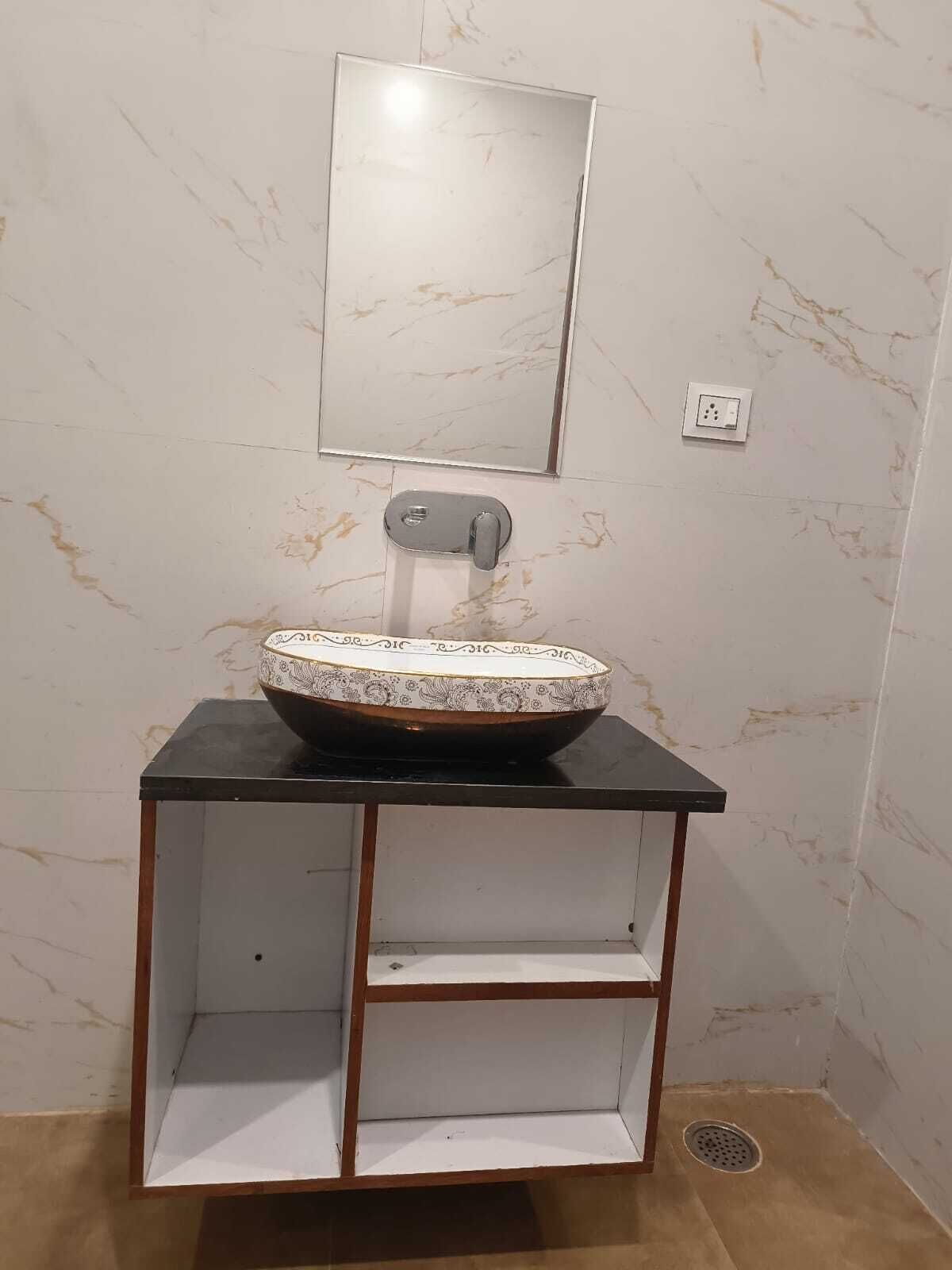 Een badkamer met een marmeren wastafel, een spiegel en een plank.