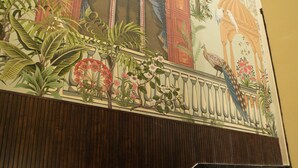 A staircase with a mural depicting a peacock and tropical plants.