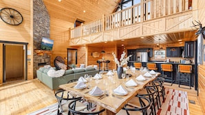 A spacious dining area with a high wooden ceiling and a balcony overlooking the kitchen.