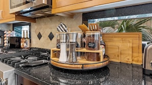 A kitchen with a gas stove, a coffee station with jars labeled 'Ground Coffee' and 'White Tea', and wooden cutting boards. - Destin: Private Beach, Pool, 4 En-Suites (Destin)