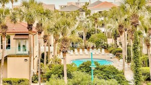 A resort with a pool surrounded by palm trees and lounge chairs. - Destin: Private Beach, Pool, 4 En-Suites (Destin)