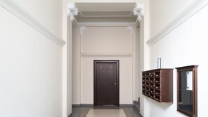 Un pasillo con una puerta de madera oscura, un archivador empotrado en la pared y un cuadro enmarcado.