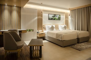 A modern hotel room with a large bed, a desk, and a chair.