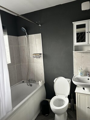 Ein Badezimmer mit Badewanne, Toilette und Waschbecken.