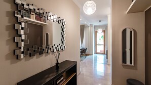 A modern hallway with a decorative mirror, a console table, and a pendant light. - Cernobbio Garden View (Cernobbio)