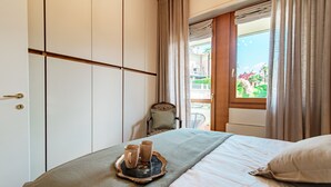 A hotel room with a bed, a chair, and a window with curtains. - Cernobbio Garden View (Cernobbio)