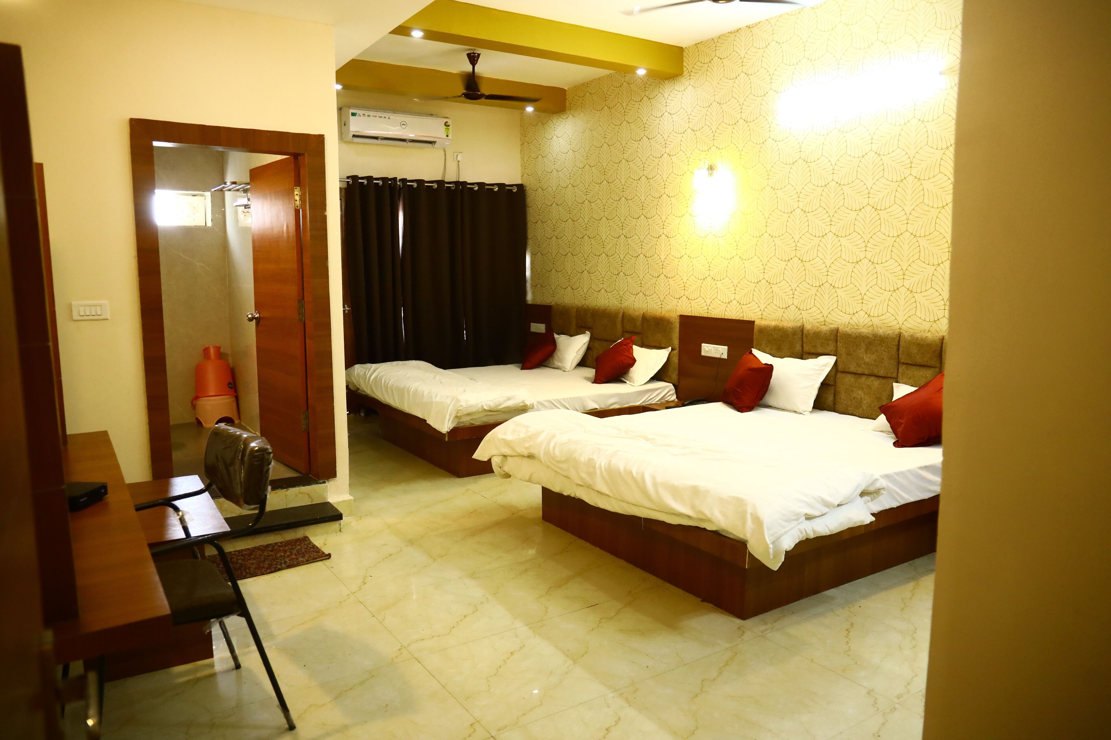 A hotel room with two beds, a desk, and a chair.