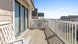 A wooden deck with white railings and a view of the ocean. - NEW LISTING-UPDATES!-4br 4ba-DOG FRIENDLY-towels,linens,pool club.<br>Golf cart friendly (Ocean Isle Beach)