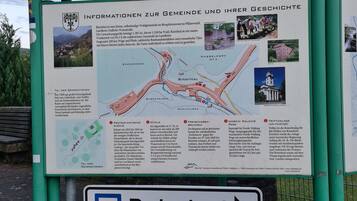 Un cartel con información sobre Rinnthal, que incluye un mapa y fotografías de lugares de interés locales.