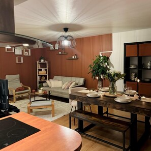 Relax in this inviting living space with a sofa, dining table, and TV.
