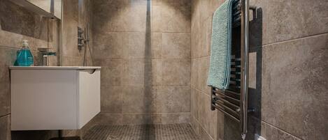 A modern bathroom with a shower, a toilet, and a sink.