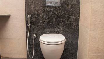A bathroom with a toilet, a shower, and a wall-mounted flush handle.