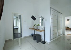 A modern bathroom with a large mirror, a vanity with a sink, and a shower area.