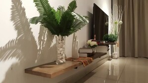 A modern living room with a wooden console table, a large fern plant, and a decorative vase. - Fun Villa 16-22px Pool BBQ Netflix KTV (Bandar Penawar)