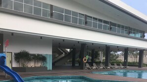 A swimming pool with a blue slide, lounge chairs, and a covered area with stairs. - Fun Villa 16-22px Pool BBQ Netflix KTV (Bandar Penawar)
