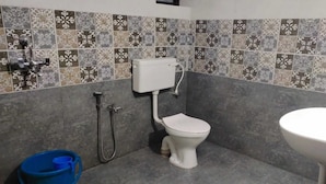 A bathroom with a toilet, a sink, and a shower. - GoanFiesta Beach House Calangute (Calangute)