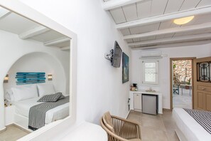 A compact room with a bed, a chair, a small kitchenette, and a bathroom. - Ep Avlis Apartments (Naxos)