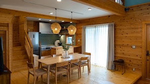 A wooden interior with a dining area, kitchen, and staircase. - IZA oumimaiko (Otsu)
