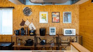Une cuisine avec des murs en bois, une horloge et divers appareils électroménagers.