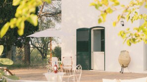 A patio with outdoor furniture, a table with a bottle, and a grill. - Tenuta Doxi (Sannicola)