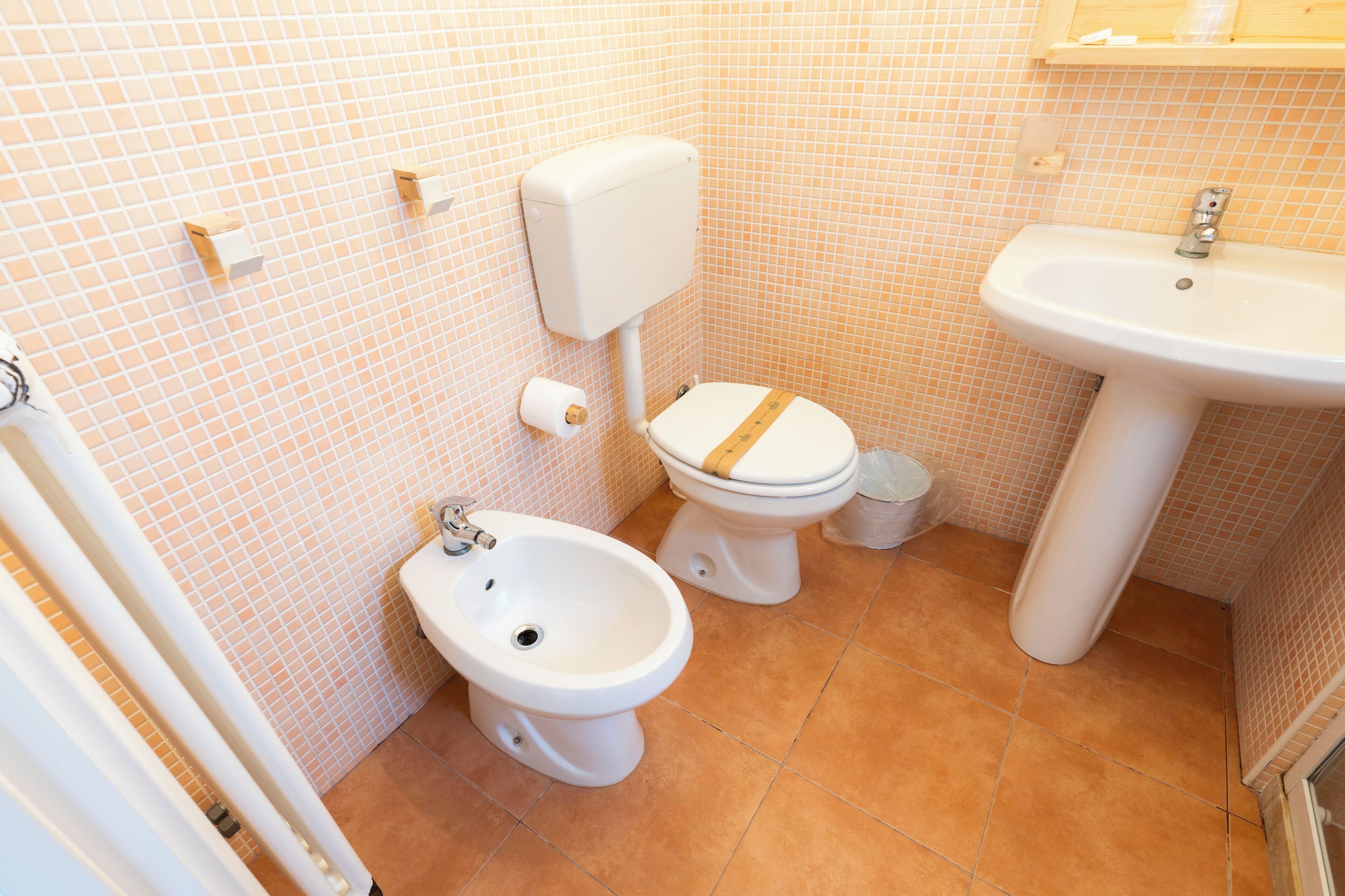 A bathroom with a toilet, bidet, and sink.