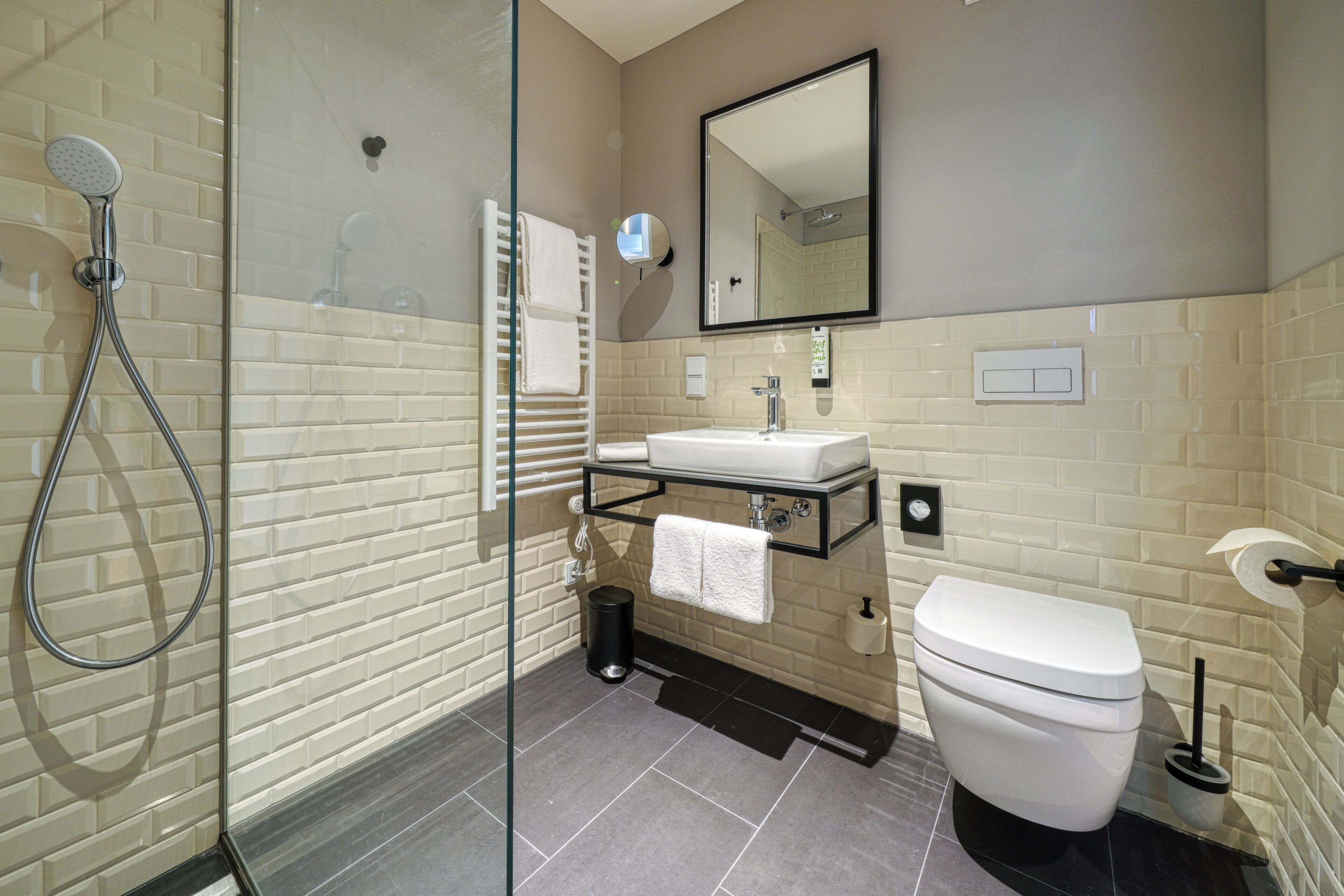 Un baño moderno con cabina de ducha de vidrio, lavamanos blanco y inodoro.